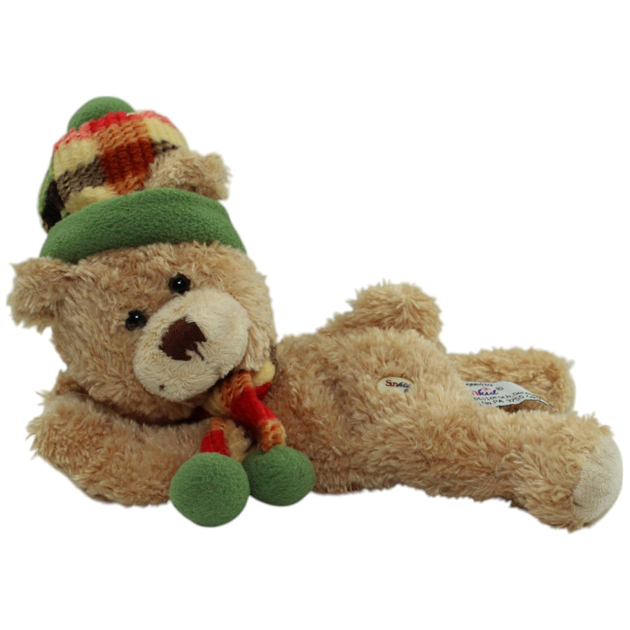 Liegender Teddybär mit Mütze und Schal
