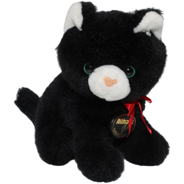 Schwarze Katze mit roter Schleife, sitzend