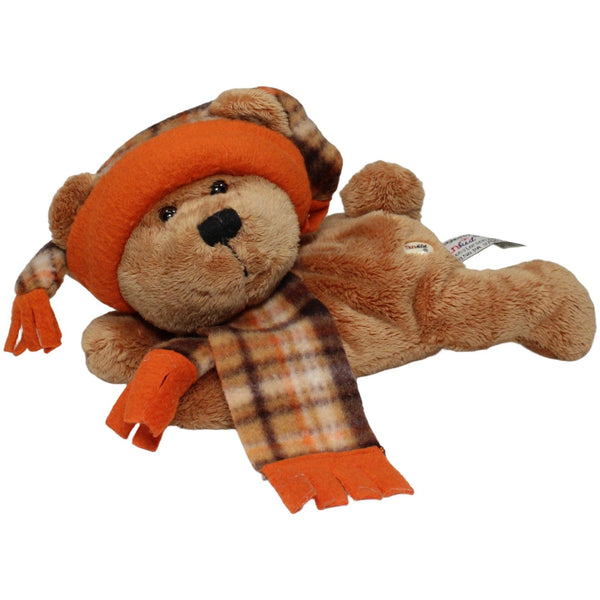 Liegender Teddybär mit Mütze und Schal